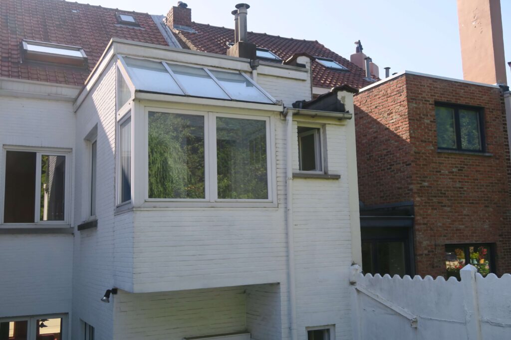 Ancien w-c refermé par installation d'un châssis et d'une verrière en aluminium, dans le cadre de la fermeture d'un balcon à Bruxelles.