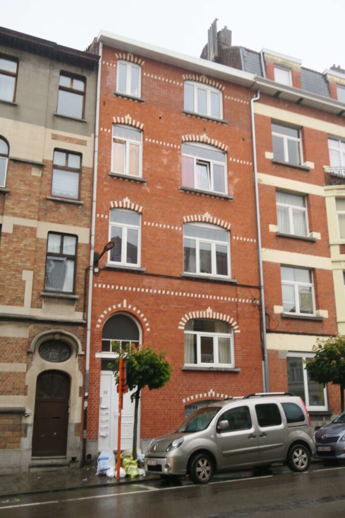 façade avant d’un immeuble mitoyen en brique ton rouge.