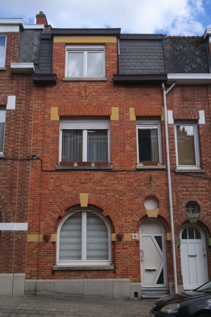 maison mitoyenne en briques jaune et rouge située dans une rue à anderlecht