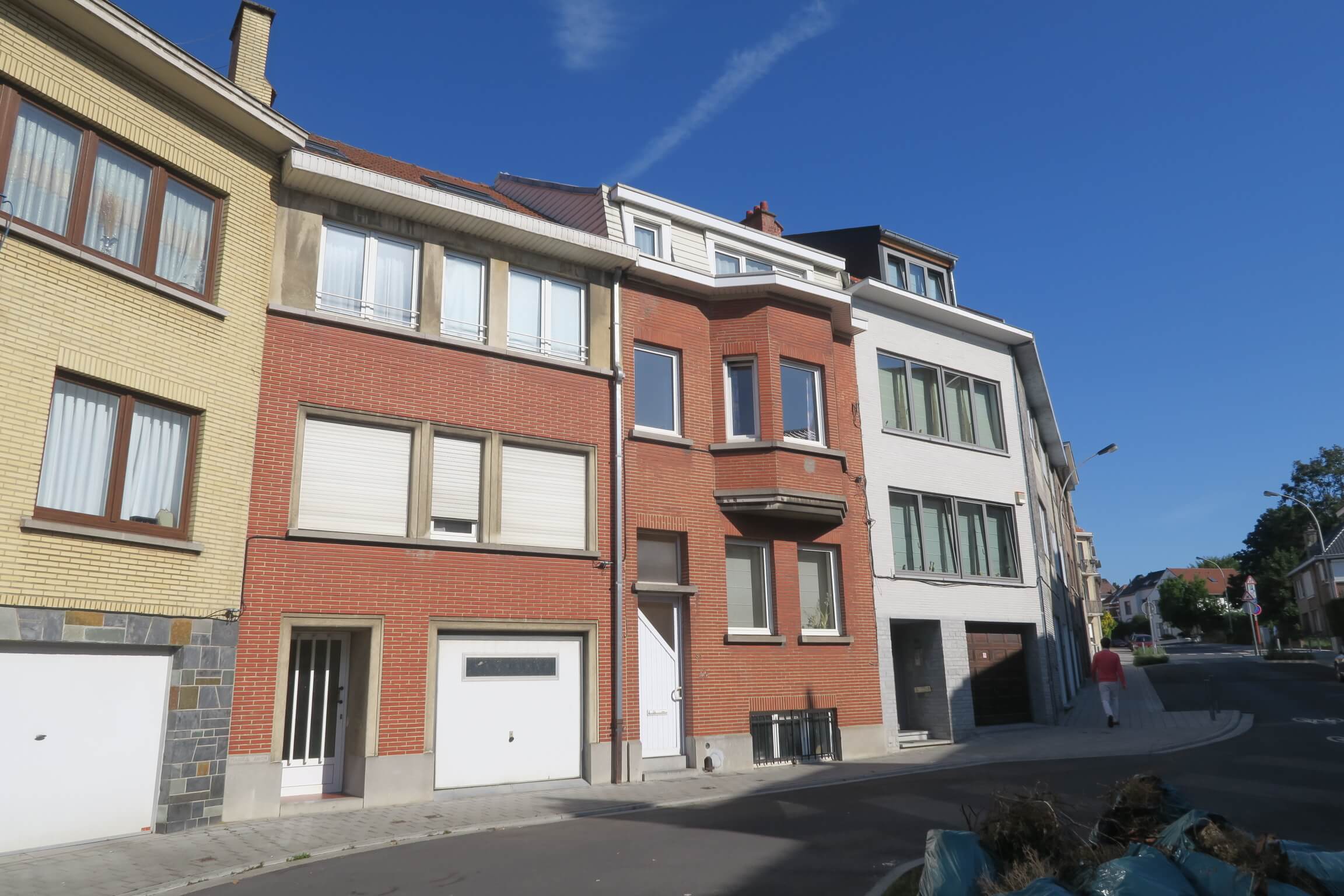 vue d’une rangée de maison en briques de couleur orange à Bruxelles avec ciel bleu