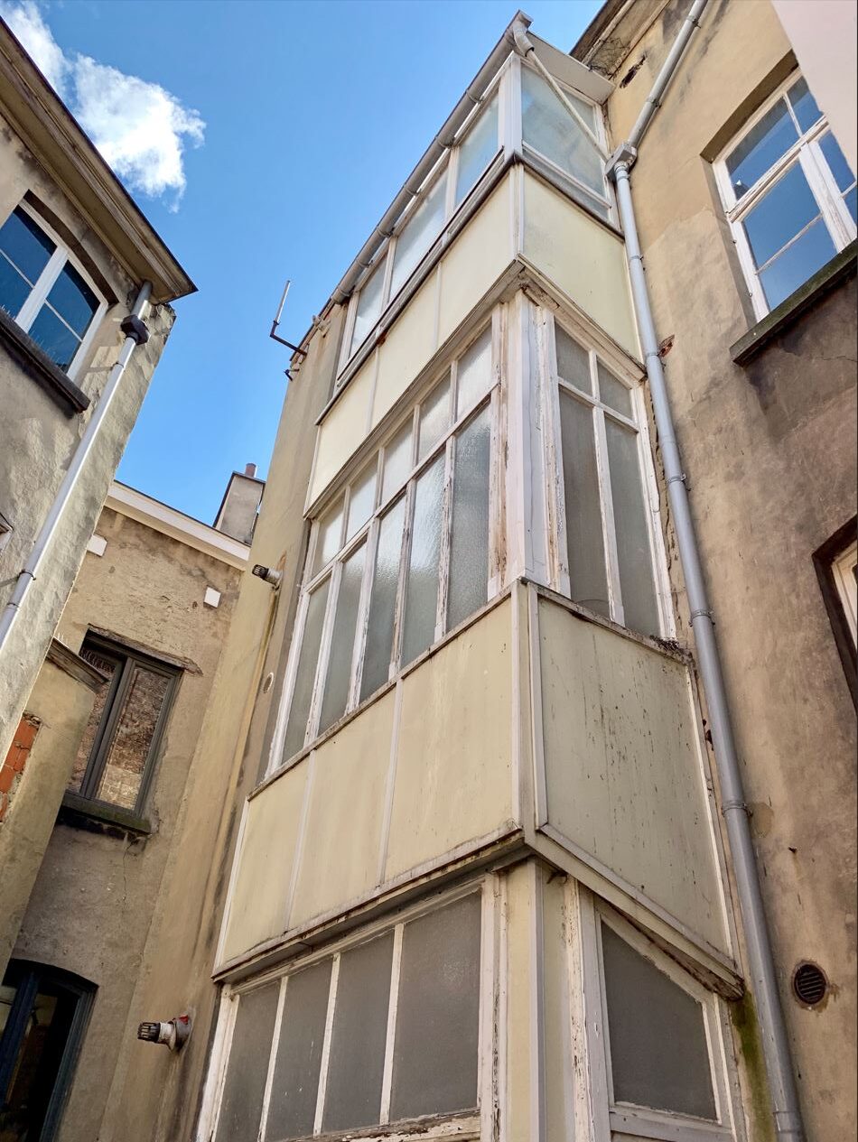 Façade arrière avec trois balcons qui ont été refermés par l'installation de châssis à etterbeek. VMAR, votre spécialiste régularisation infraction urbanistique à Bruxelles.