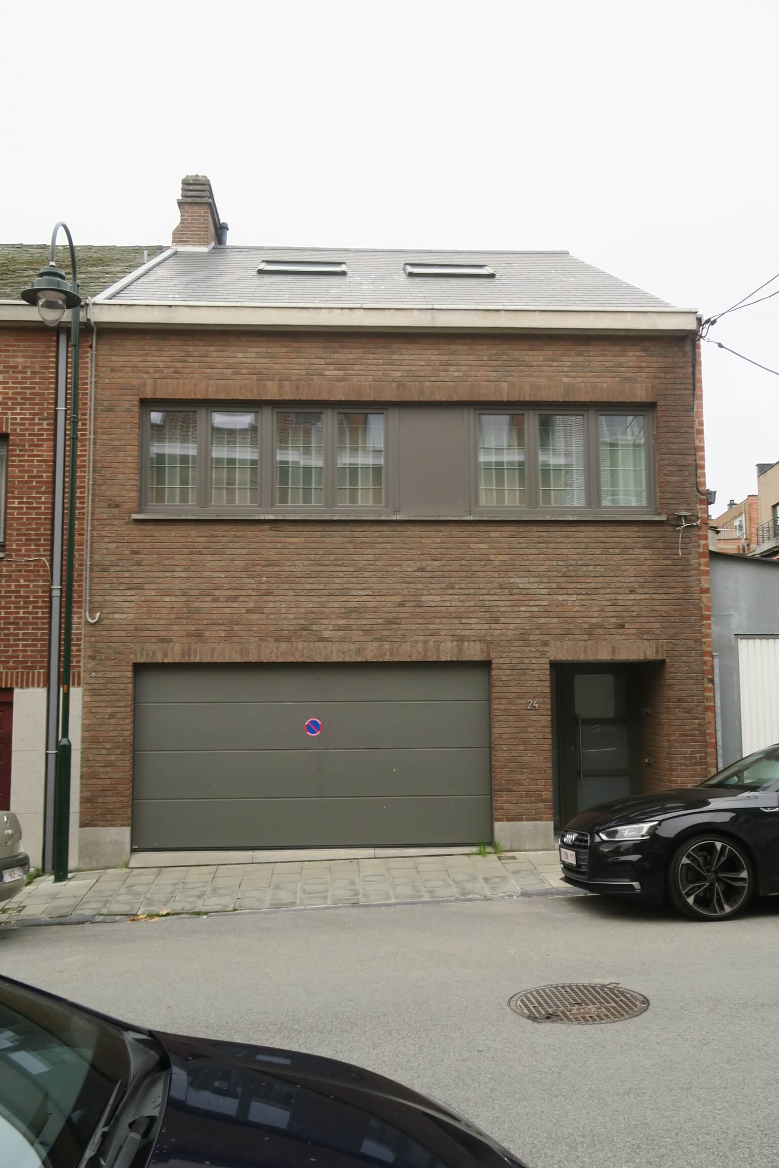 maison mitoyenne en briques brune à un étage et toiture à deux versants